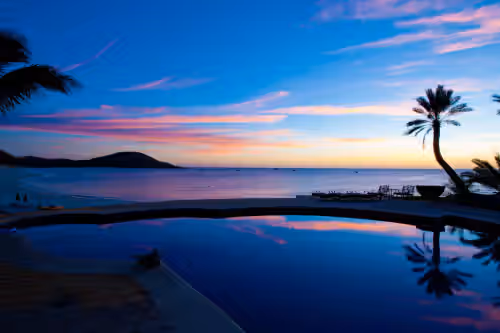 Pool with ocean view during sunset at Rancho de Costa: One-of-a-Kind Beachfront Estate on the Bay of Dreams