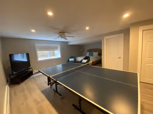 Basement bedroom features ping pong table at Lakefront Modern Mansion With Heated Pool 9BR's On Private Sandy Beach