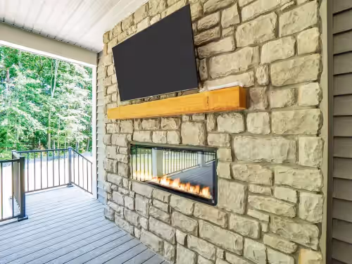 Cover Deck on main level with TV, couch, fireplace and eating area at NEW June 2024 -LAKEFRONT 9 King Bedrooms/8 bath!