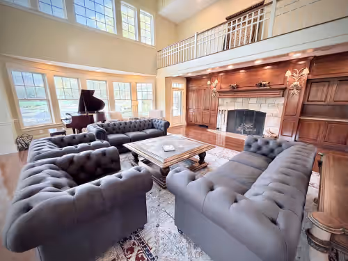 Richly decorated great room w/ seating for up to 17 + massive stone fireplace at “Eden” 8BR Luxury Retreat with Pool, Spa,