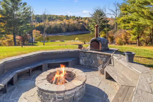 Fire pit and taboon (pizza) oven with views of the lake at Lakefront Paradise: Views, Heated Pool, Games! Summer & Winter