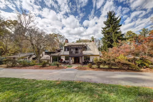 View from the back yard at Historic 8 BR Tudor on 3 1/2 Acres. Private estate and beautiful setting