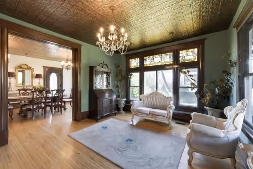 Original tin ceiling and crystal chandelier on the first floor of the mansion. at Stunning Historical Mansion: 8 bedrooms
