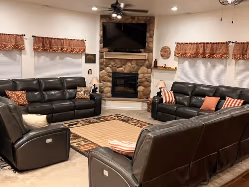 The Great Room with River Rock Fireplace and 55" TV for your enjoyment together. at MAMA BEAR CABIN -RUSTIC LOG Cabin Retreat
