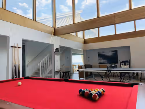 Enjoy the natural lighting of the game room with scenic ocean views at Unobstructed Direct Oceanfront in Seaside